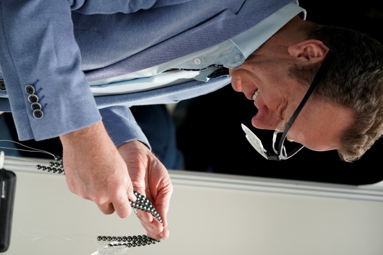 Jeremy Shepherd Examines strands of black pearls at the Hong Kong pearl show