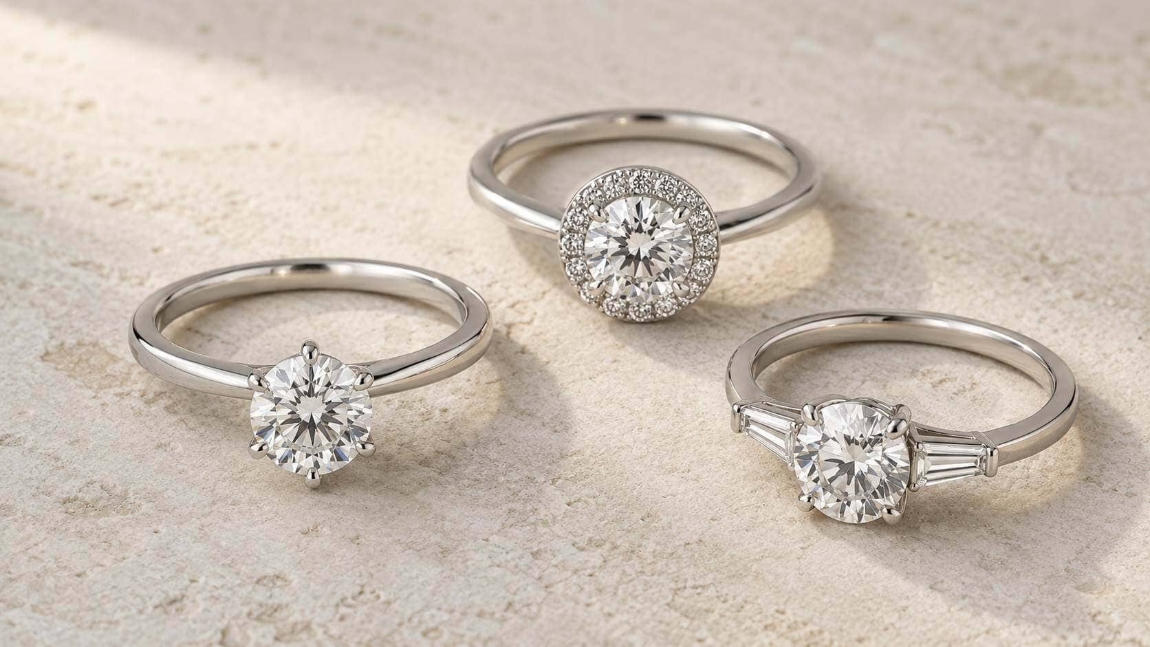 Three white-gold lab-grown diamond rings in solitaire, halo and three-stone settings, comparing their overall visual presence.