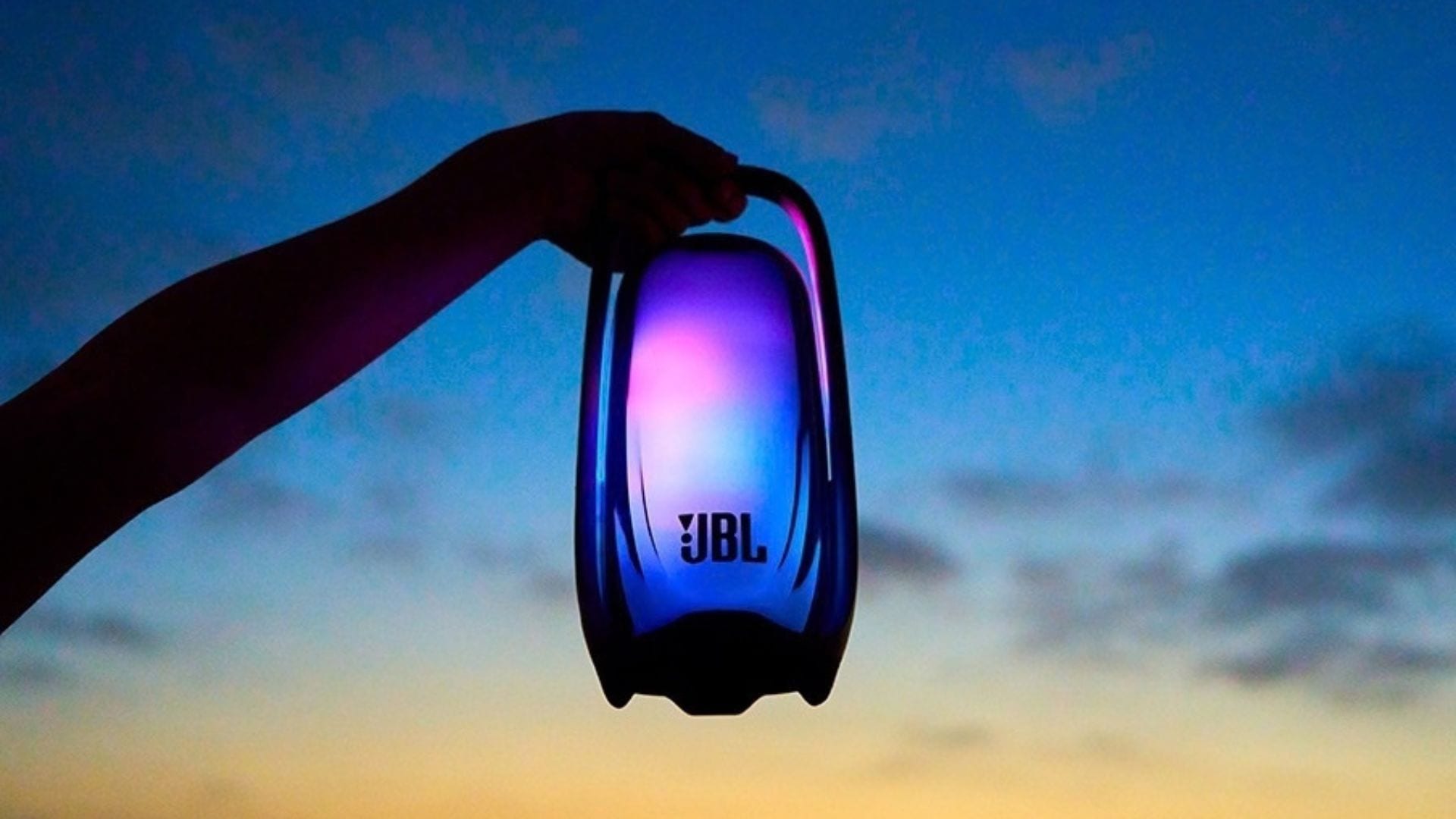 JBL Pulse 6 portable speaker glowing in a lifestyle setting