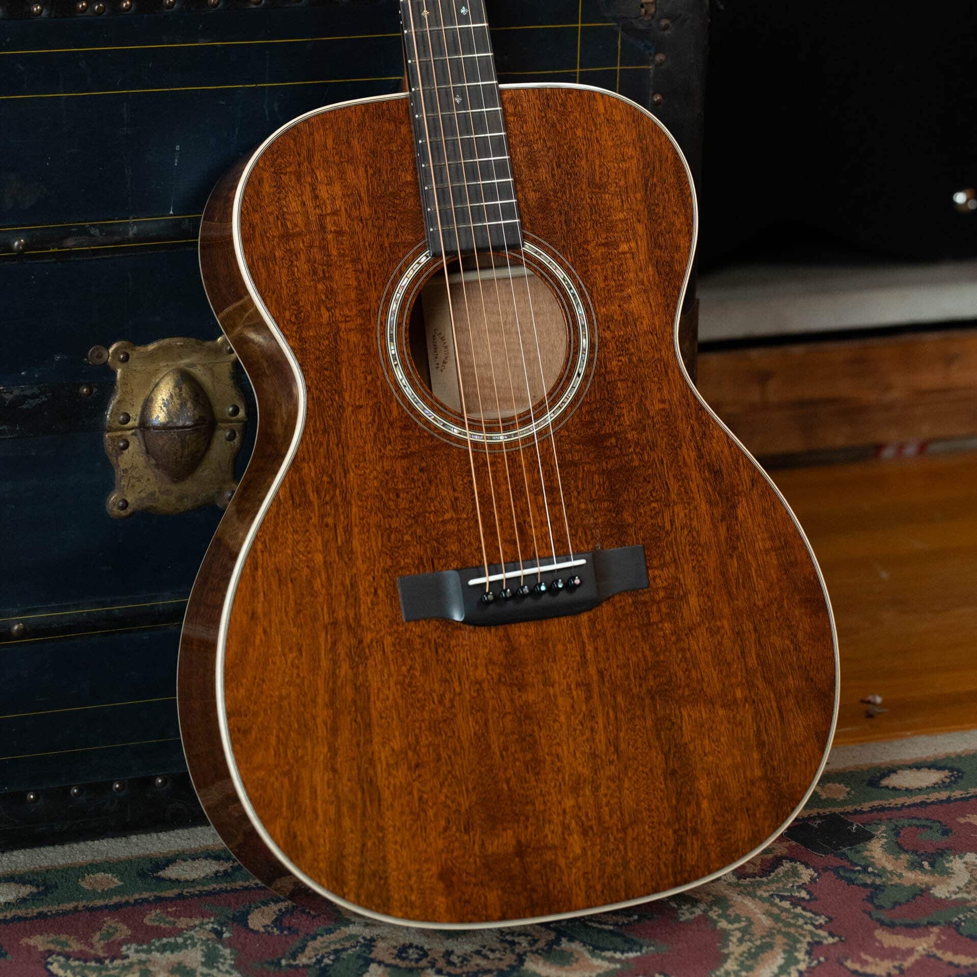 Martin Custom Shop 000-17 style guitar in all flamed mahogany, laid on a wood floor