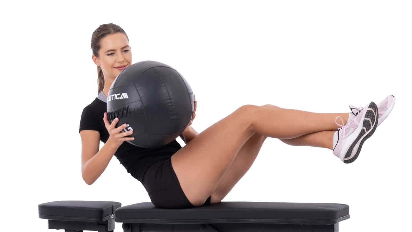 Gymnastikball Übungen auf der Hantelbank
