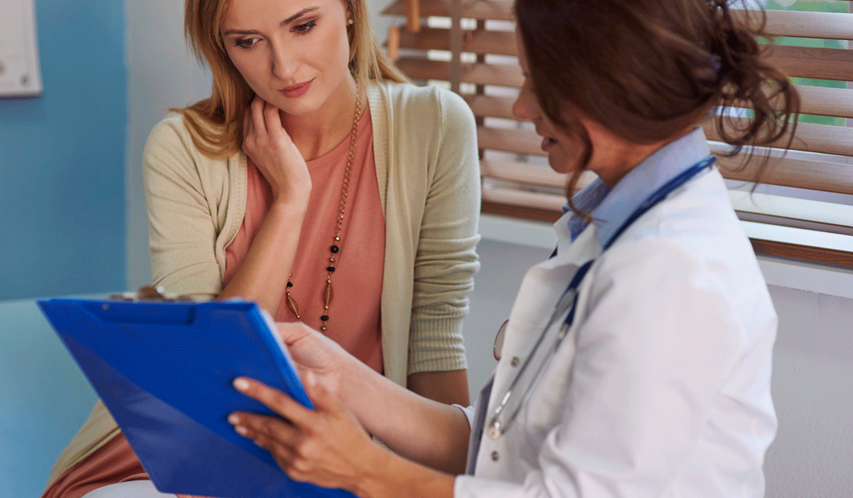 Doctor discussing medical results on clipboard with female patient