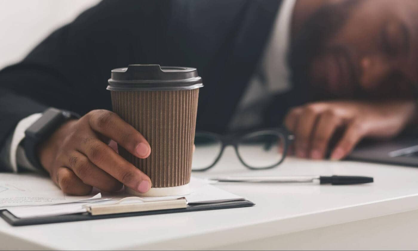 Tired businessman holding a cup of coffee.