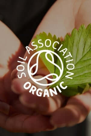 Hands cupping fresh green leaves with Soil Association Organic certification logo overlay
