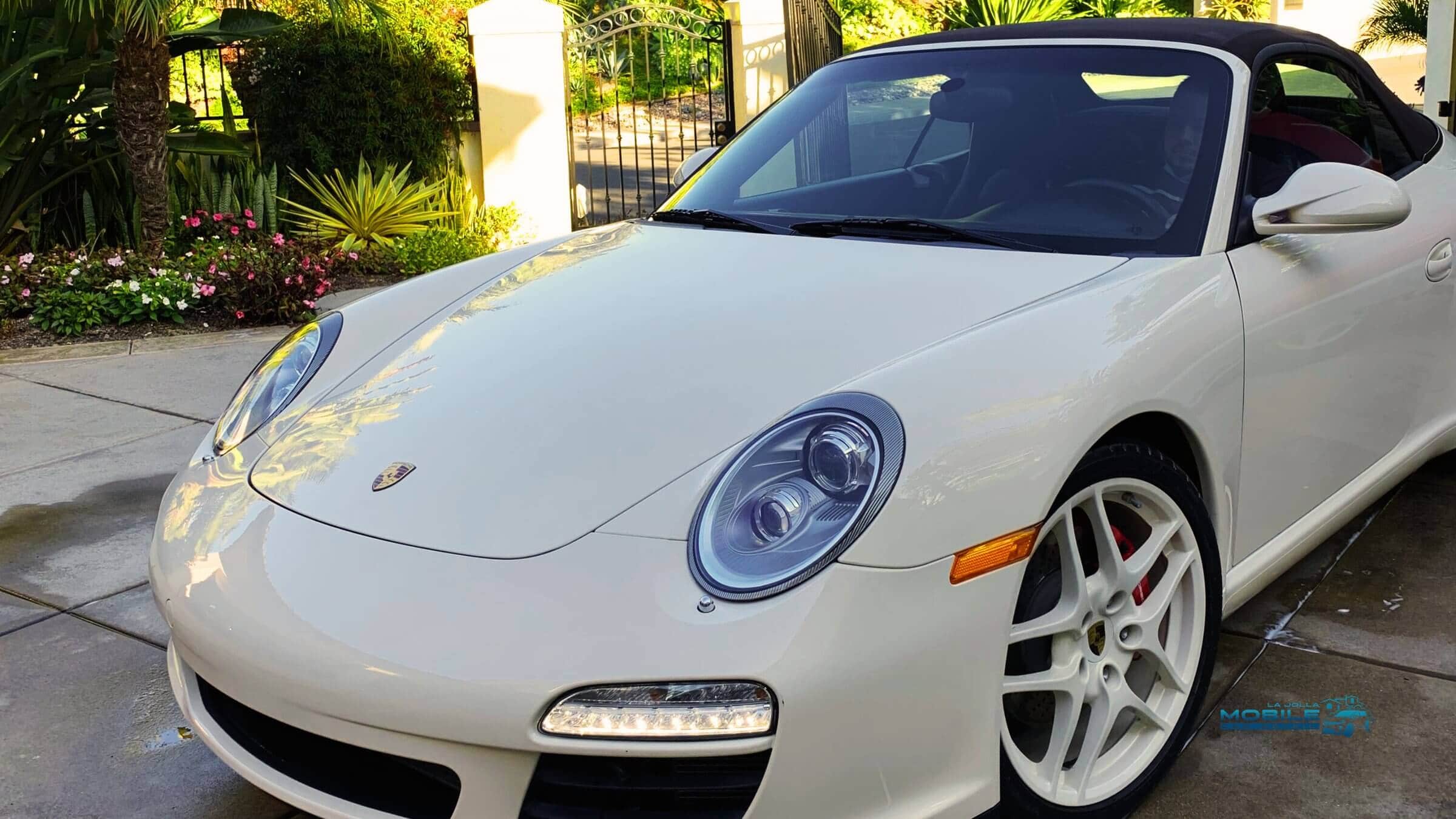 White Porsche 911 with glossy finish after car wash and wax service in San Diego driveway