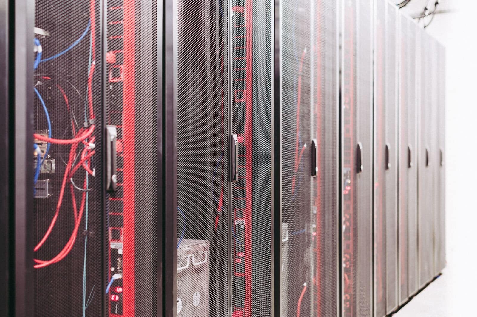 Row of server racks with cabling in a secure data center, representing where a video redaction company should store agency footage