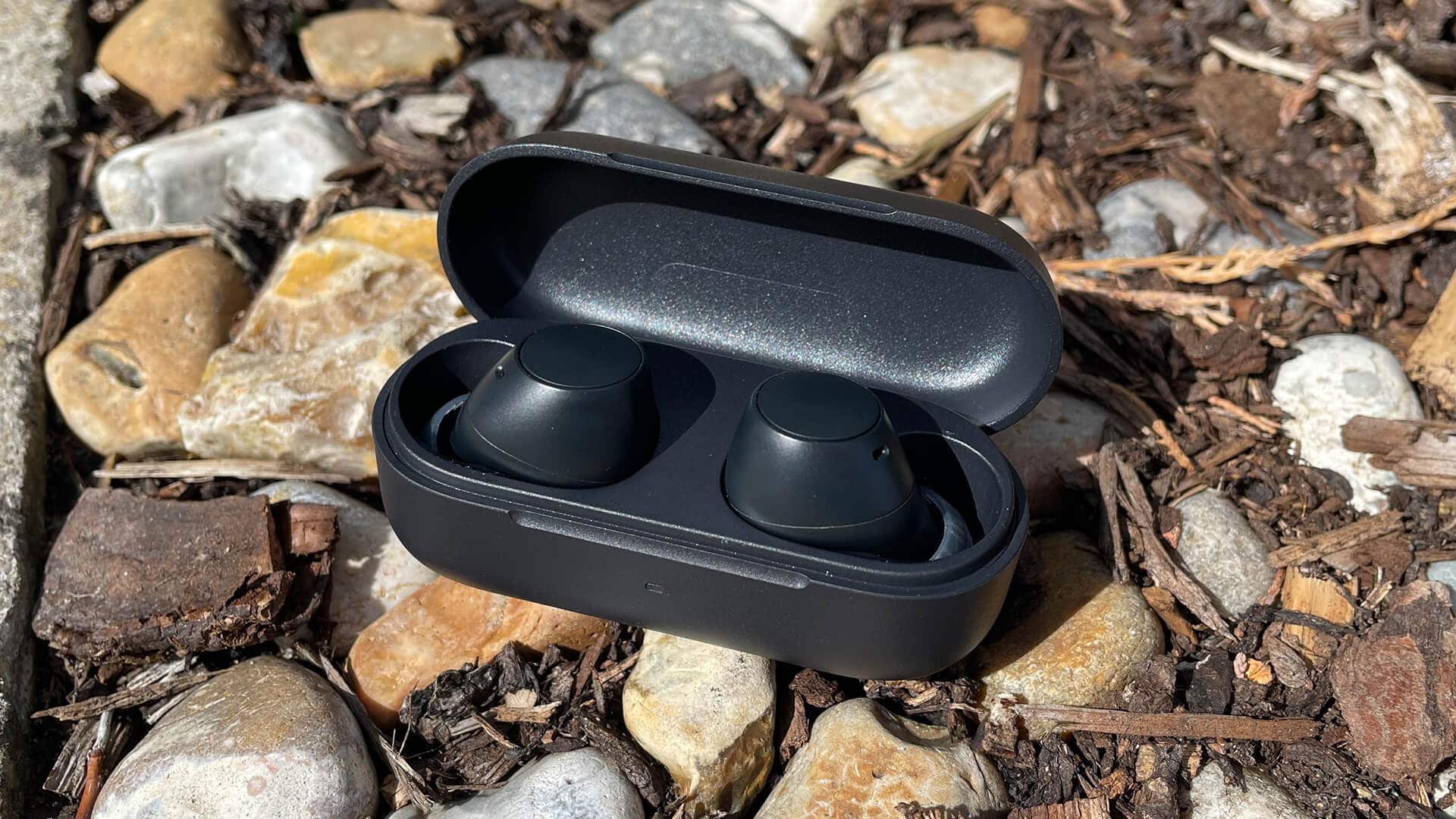 Sony WF-C510 earbuds in open charging case on rocky ground