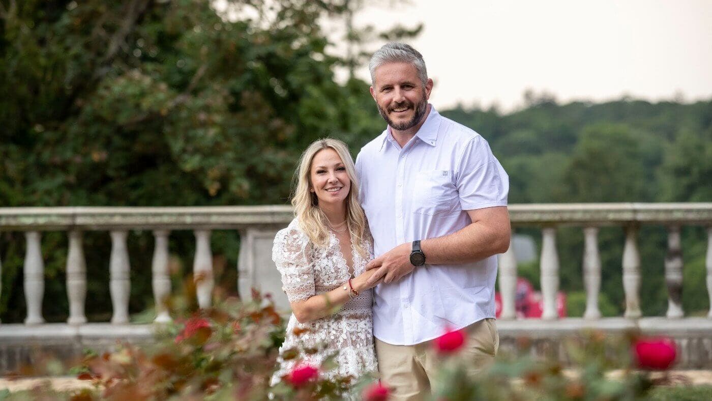 Myles and Emily Fee standing in Reid Castle terrace rose garden