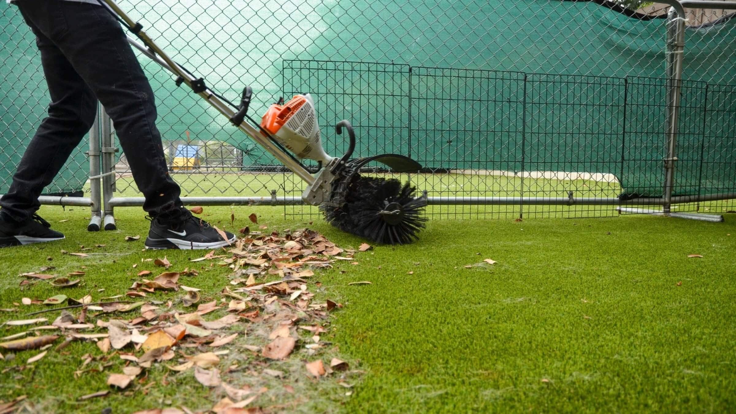A man cleaning an artificial turf