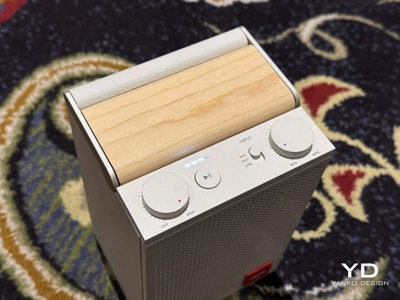 Top view showing tactile volume knobs and speaker interface