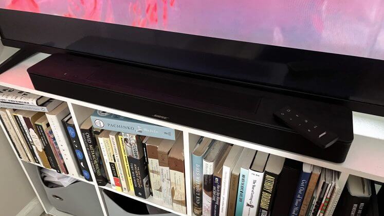 Bose Smart Soundbar positioned on TV stand.