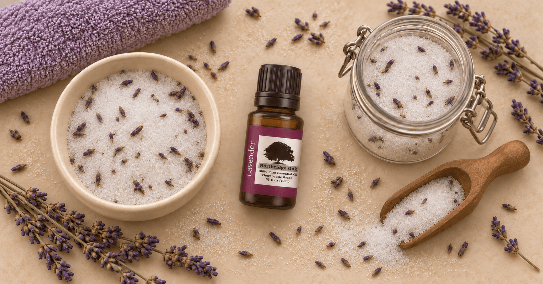 Northridge Oak Lavender Essential Oil beside homemade lavender bath salts, a wooden scoop and dried lavender flowers.