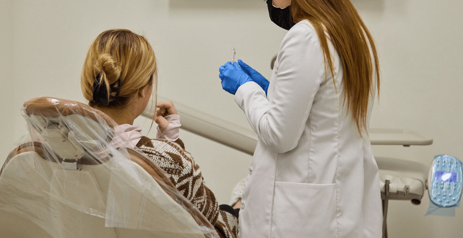 A woman sitting on a dental chair first dental implant