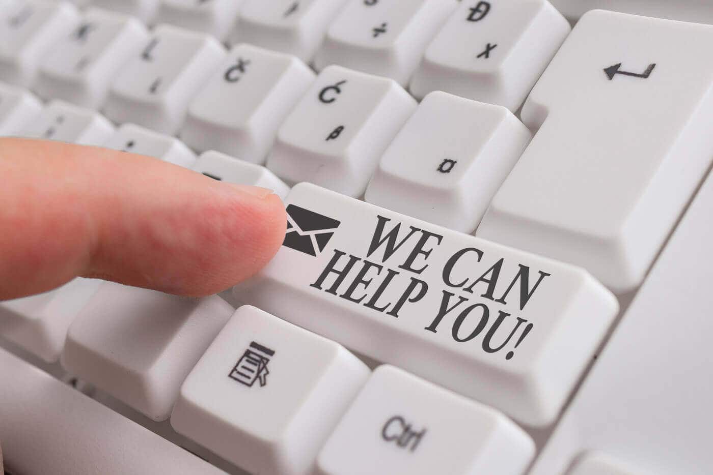 Finger pressing a keyboard key reading We Can Help You, representing help with time consuming redaction work