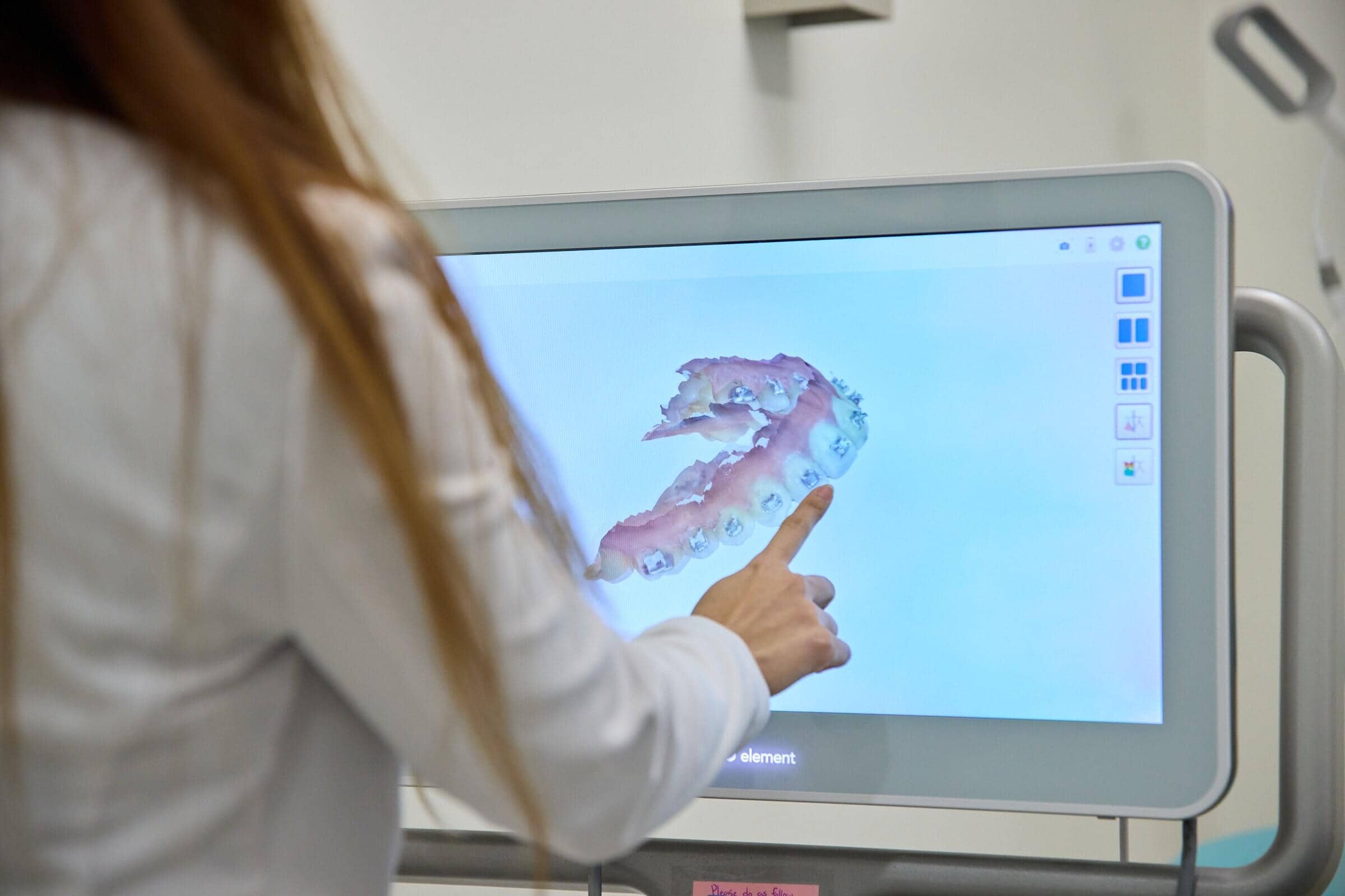 A woman pointing to a monitor