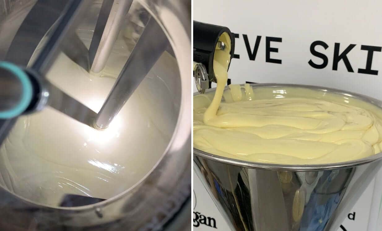 Professional laboratory mixing equipment creating smooth yellow body cream emulsion during skincare formulation development