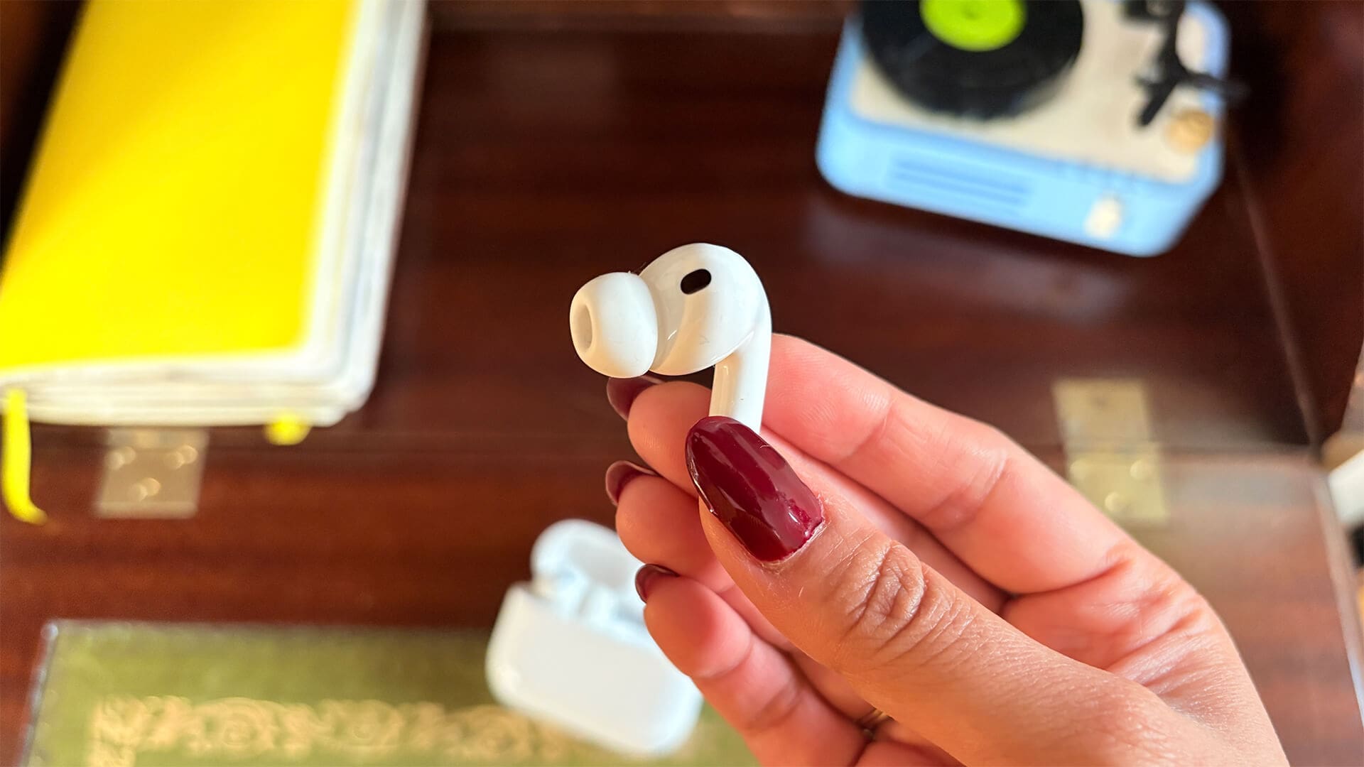 Close-up of AirPods Pro 3 earbud held between fingers