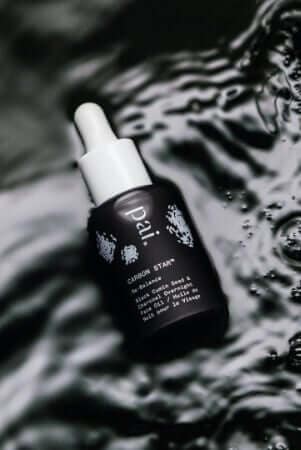 Carbon Star overnight treatment oil with dropper bottle on reflective water surface