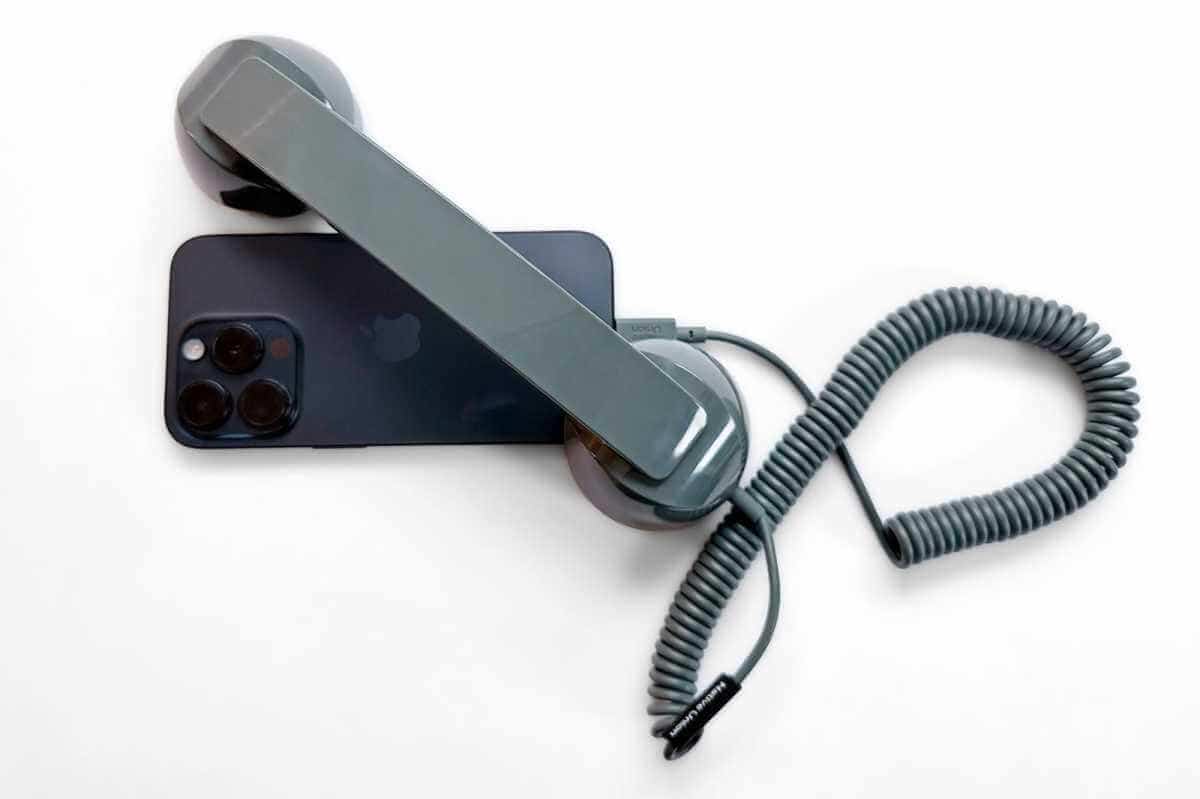 The POP handset paired with a sleek iPhone 15, mixing retro style with modern tech