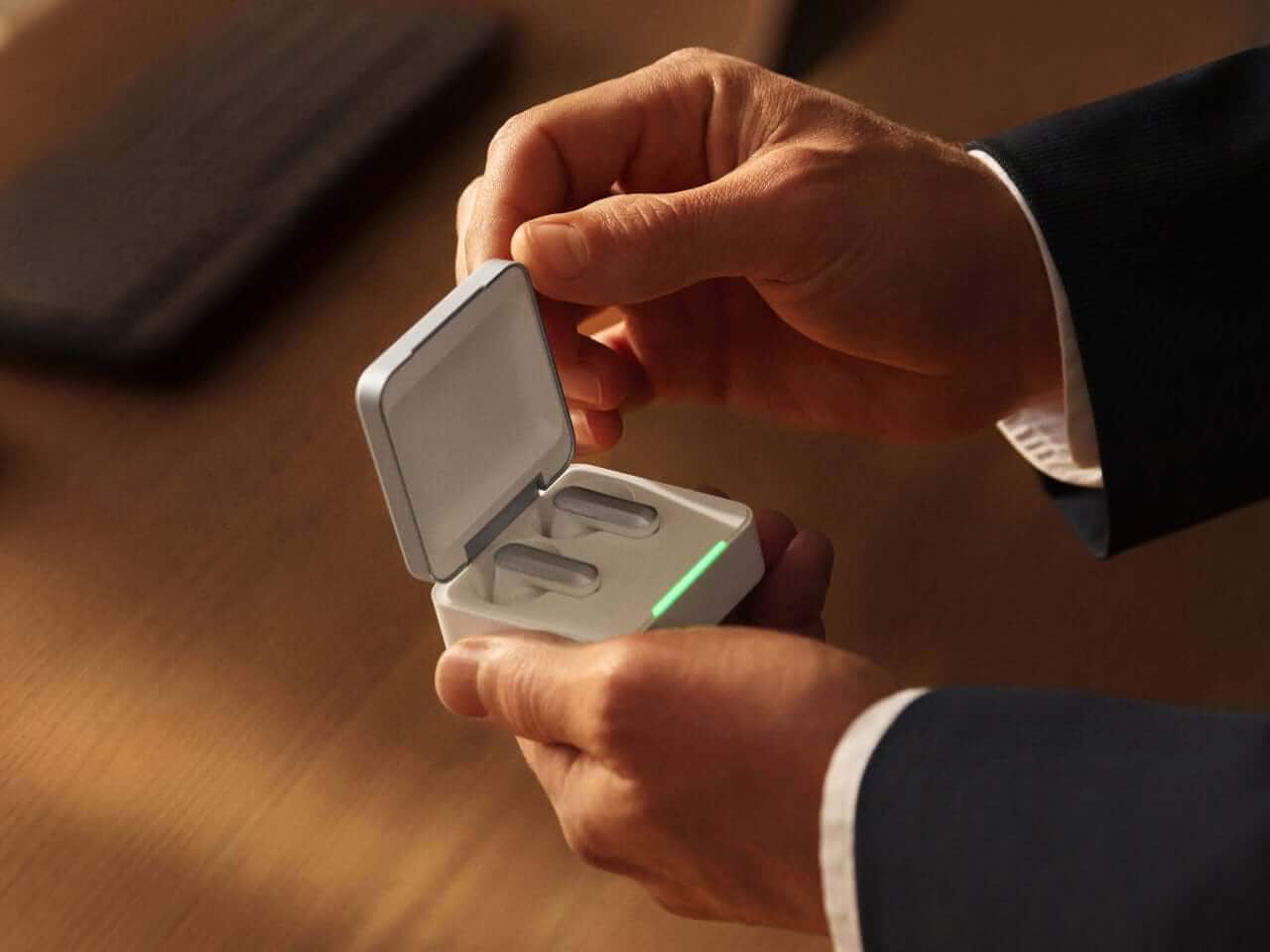 Plaud One case with earbuds positioned for charging