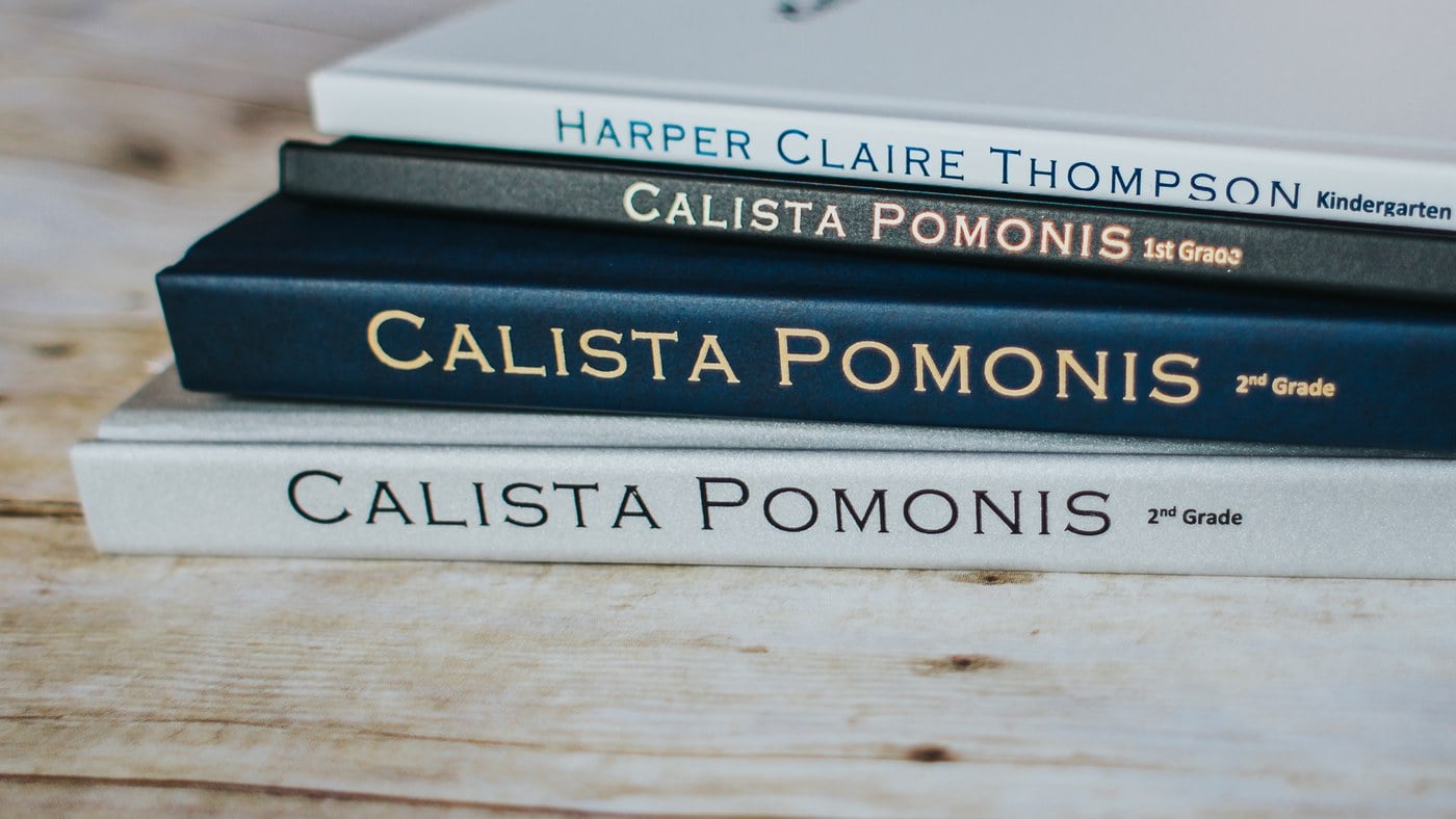 Stack of personalized elementary school memory books for kindergarten, 1st and 2nd grade