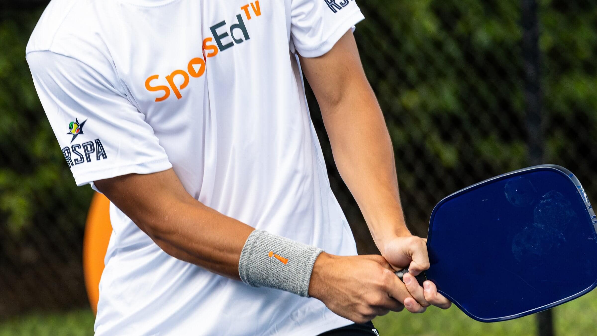 Close up shot of man holding pickleball paddle