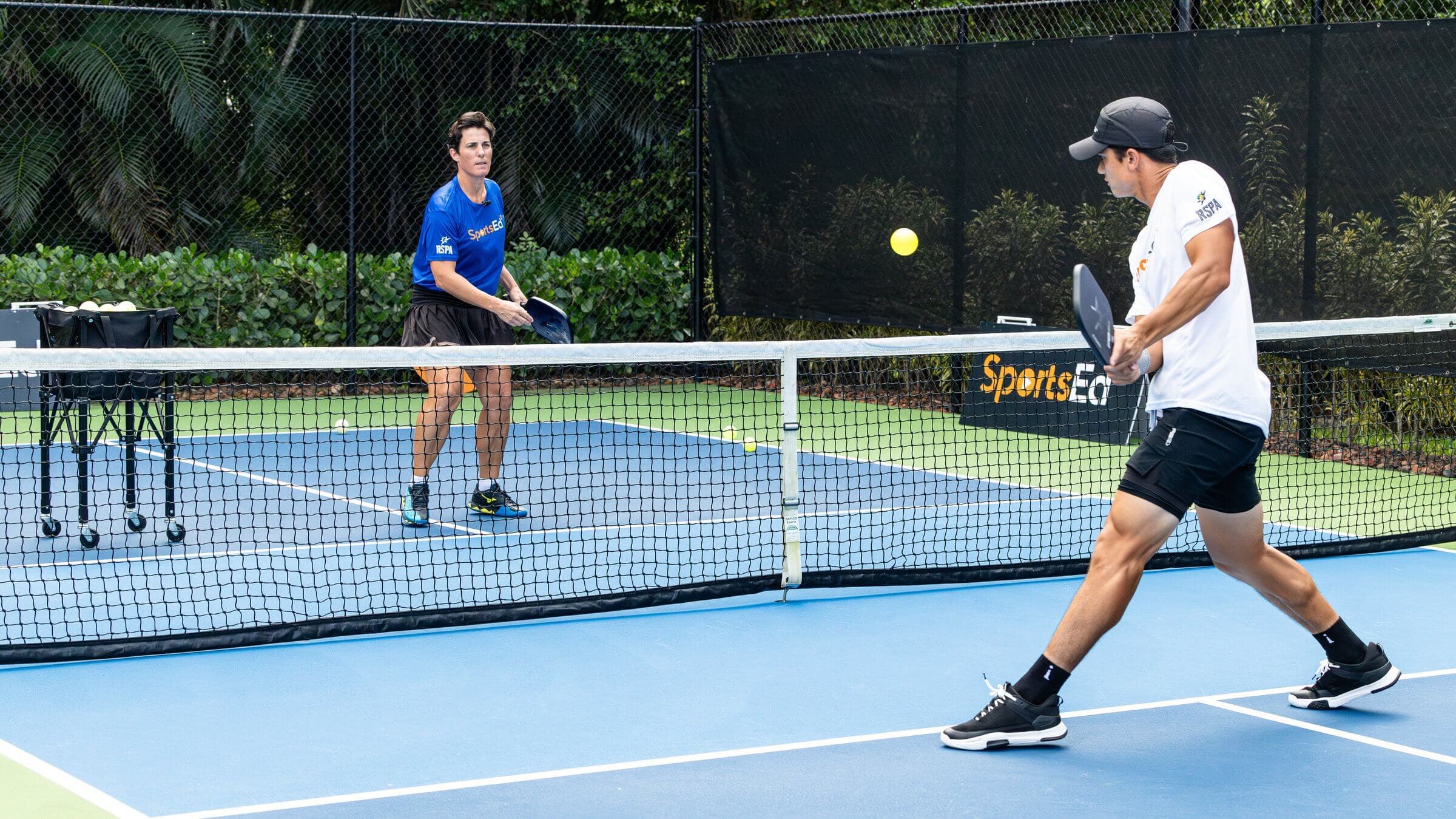 Two pickleball players in a game of pickleball