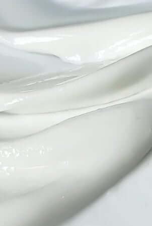 Gentle white moisturizer texture being applied, ideal for sensitive skin during chemotherapy treatment