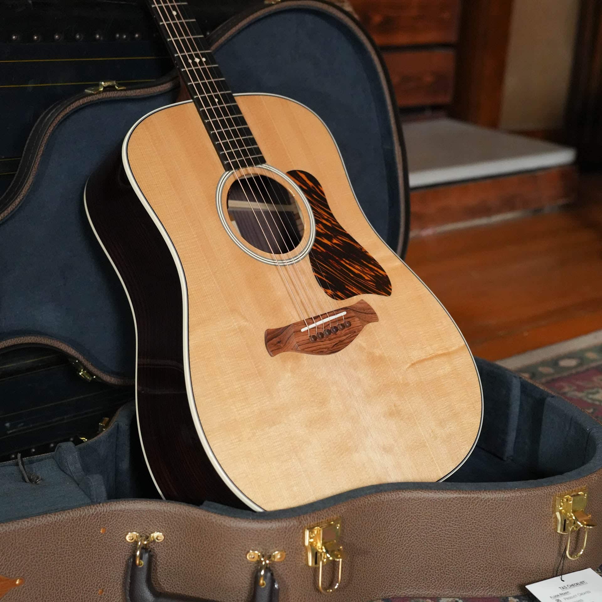 Taylor Gold Label 710e square-shoulder dreadnought with firestripe pickguard resting in its brown hardshell case