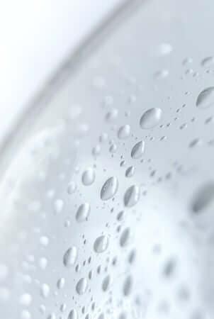 Close-up of water droplets forming on smooth skin surface showing glycerin's hydrating properties