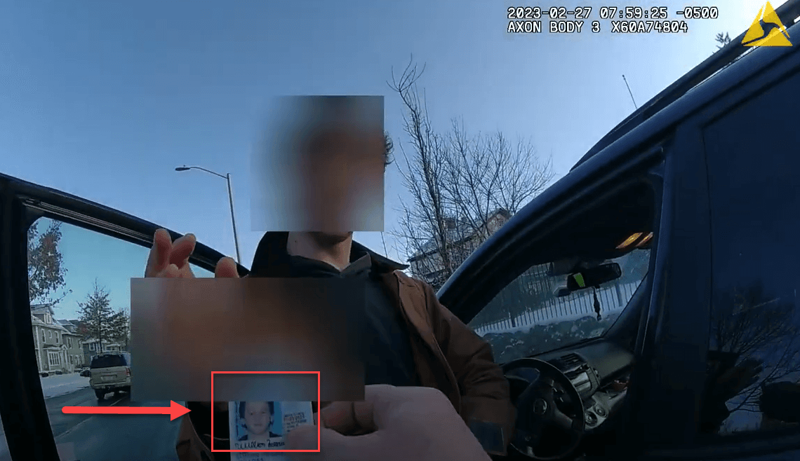 Body worn camera frame where a redaction mask slipped and exposed an identification card at a vehicle window