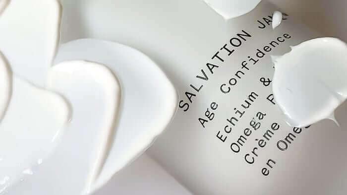 White skincare serum with ectoin ingredient label showing age confidence and skin protection benefits
