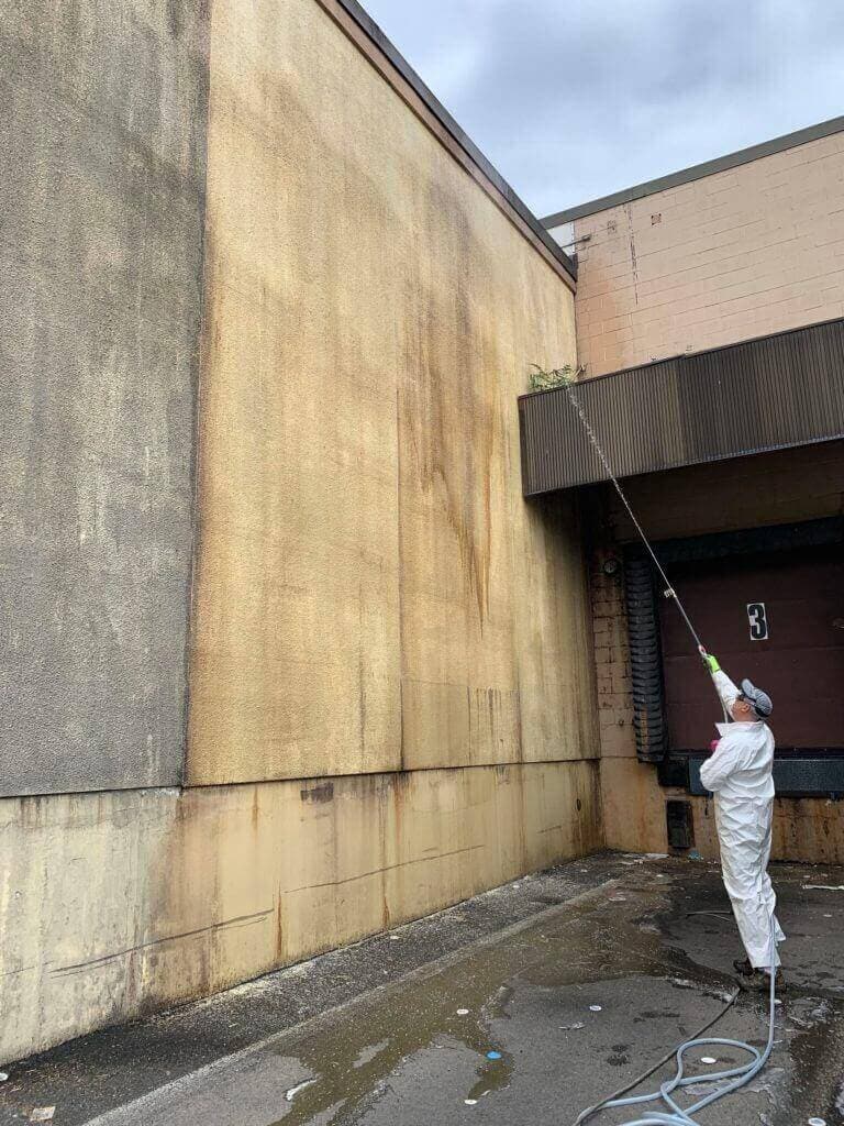 Contractor performing exterior cleaning on commercial building after J.Racenstein training
