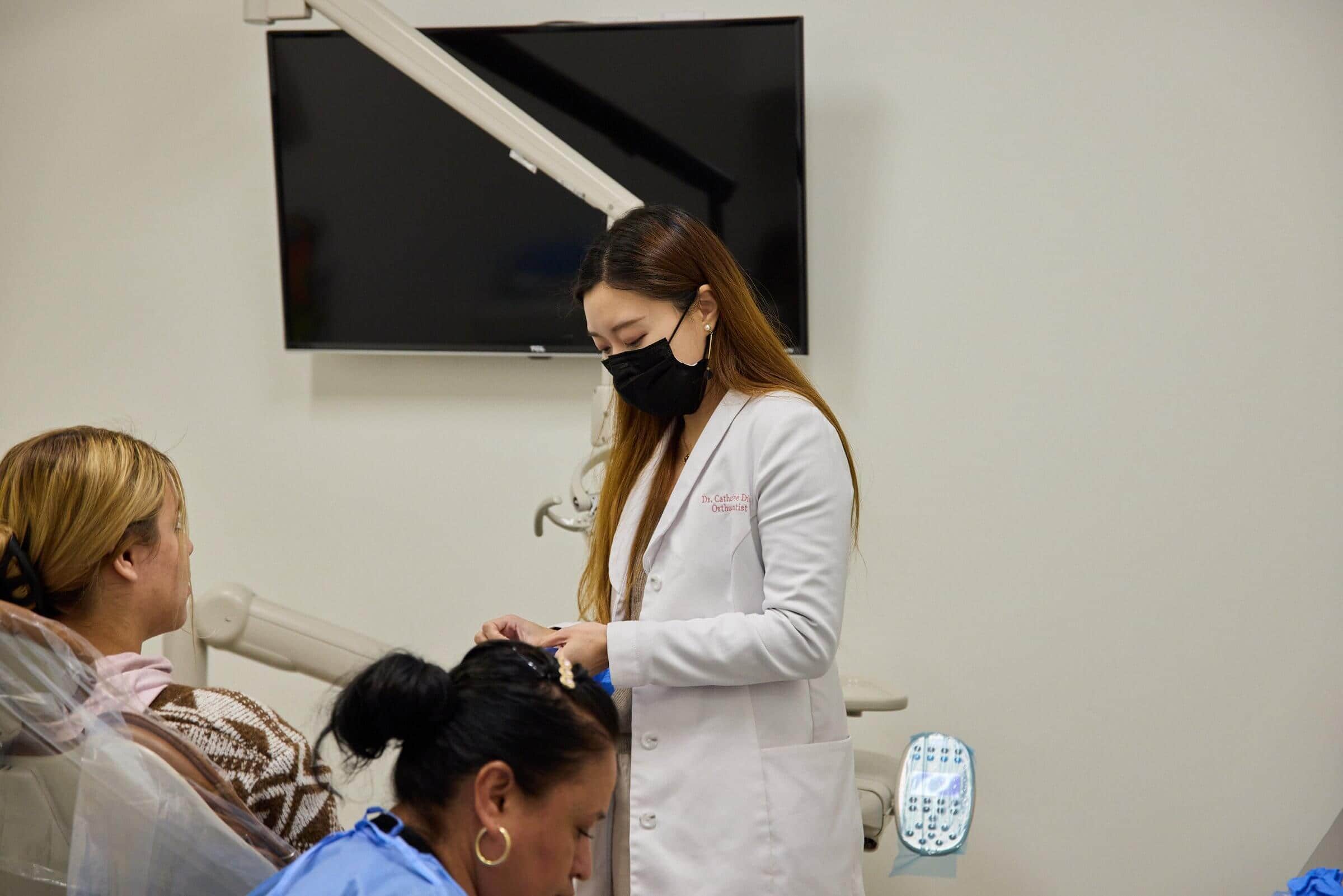 A woman talking to a patient sitting on a dental chair