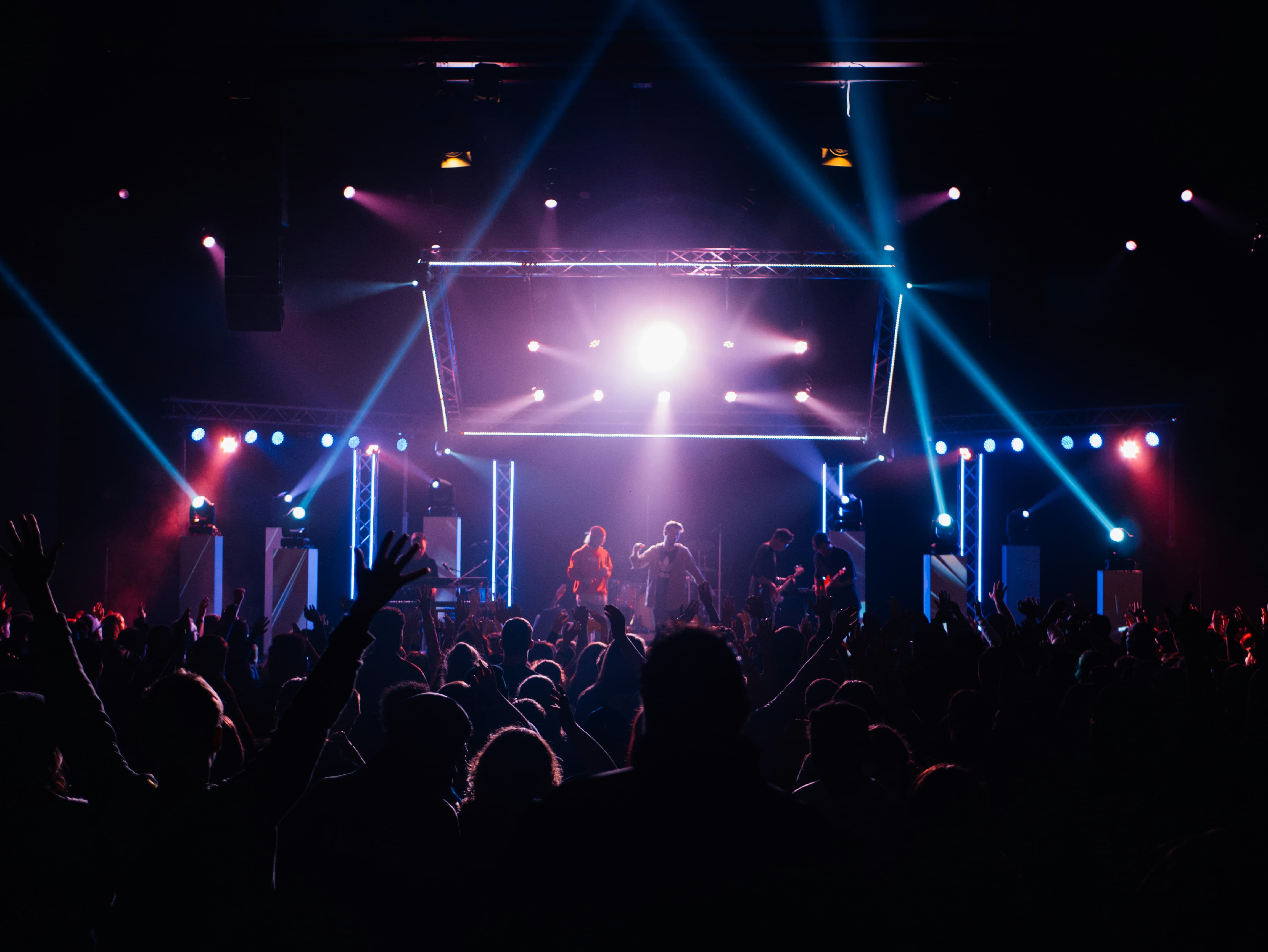 Audience watching a live band under colorful concert lights