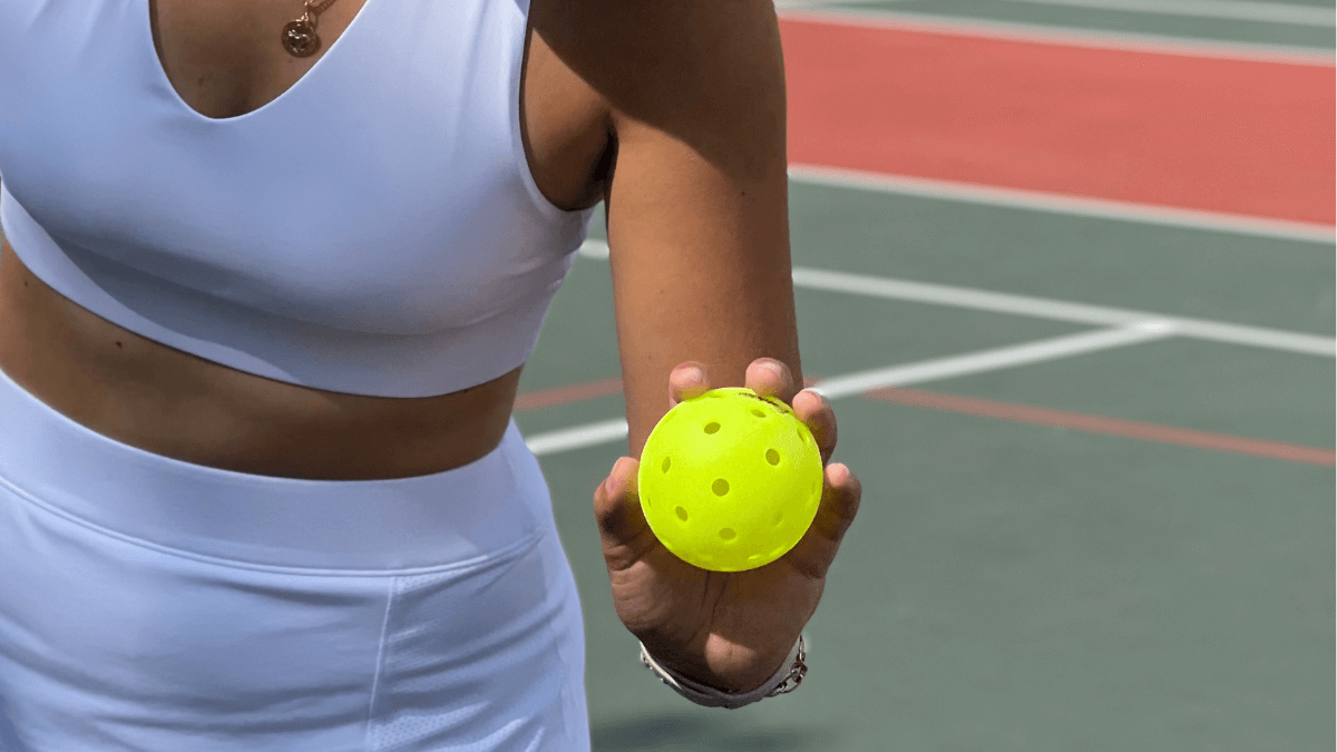pickleball player holding a pickleball