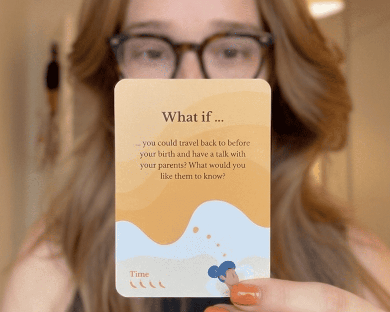 A woman holding up Scenario Cards, demonstrating how 