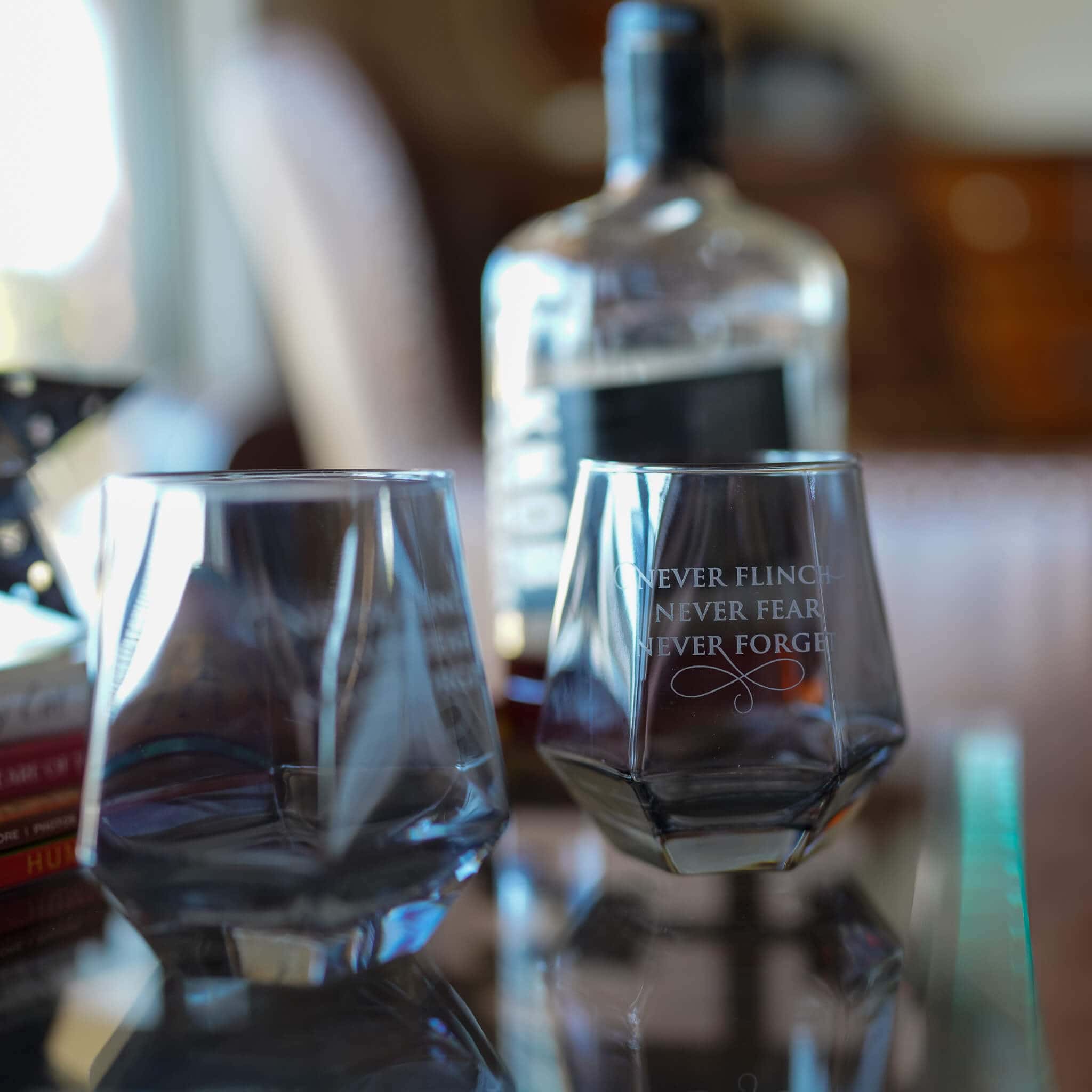 Nevernight Whiskey Glass has a hexagon shape in black tinted glass with the quote Never Flinch, Never Fear, Never Forget