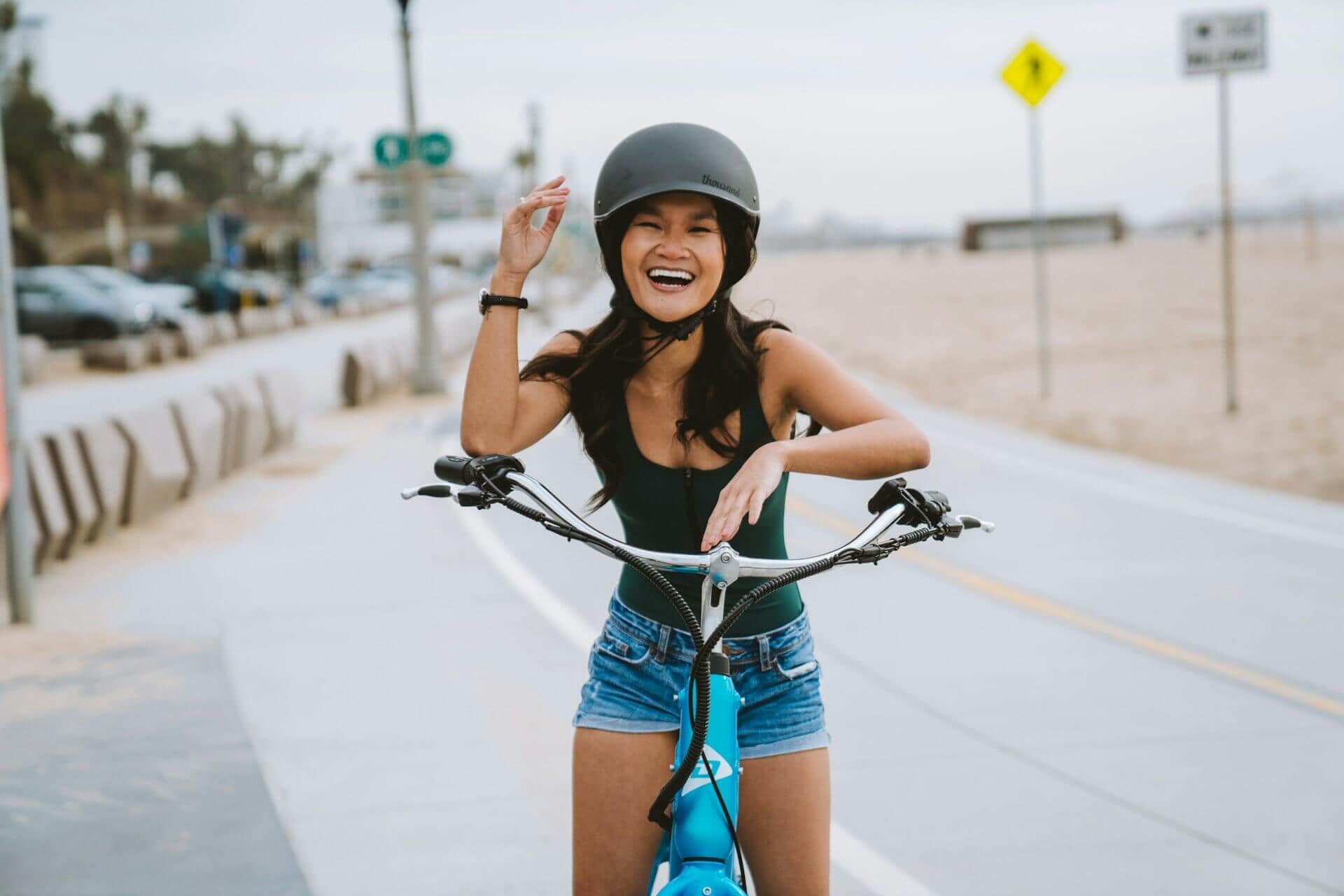 girl on a bicycle next to the beach