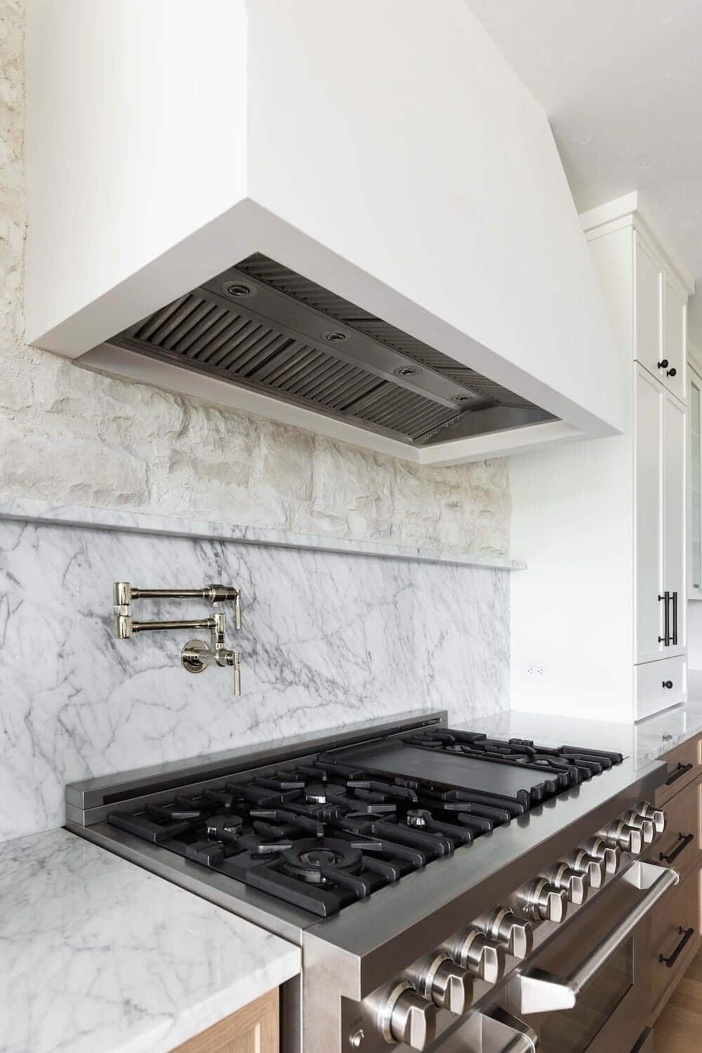 Custom farmhouse-style range hood over a large cooktop