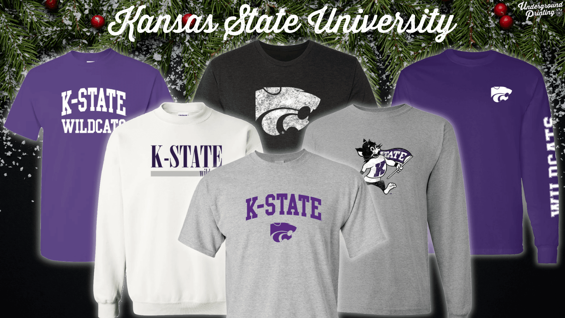 A collection of Kansas State University apparel, showcasing items with "K-State Wildcats" and the iconic Powercat logo. The pieces include a purple t-shirt with "K-State Wildcats," a black t-shirt with a large, distressed Powercat graphic, a white sweatshirt with "K-State Wildcats" printed across the chest, a gray t-shirt with a playful Wildcat mascot holding a flag, and a purple long-sleeve shirt with "Wildcats" down the sleeve.