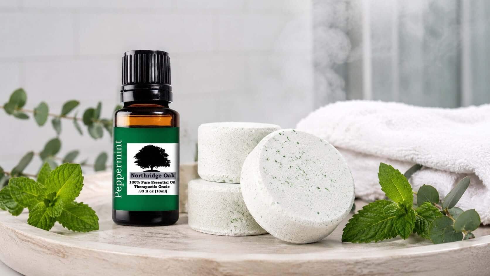 Northridge Oak peppermint essential oil with handmade shower steamers, eucalyptus, and fresh peppermint on a spa-style tray