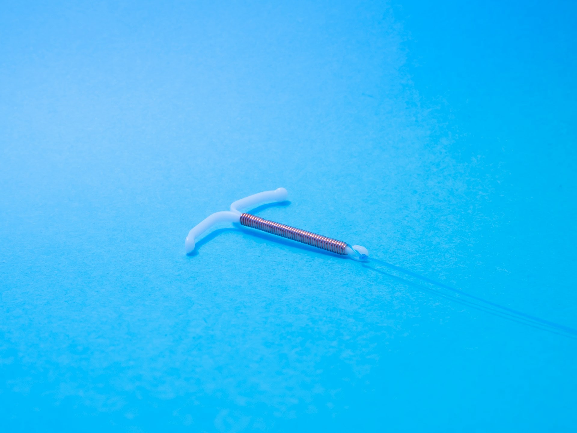 Copper IUD with white arms and blue threads