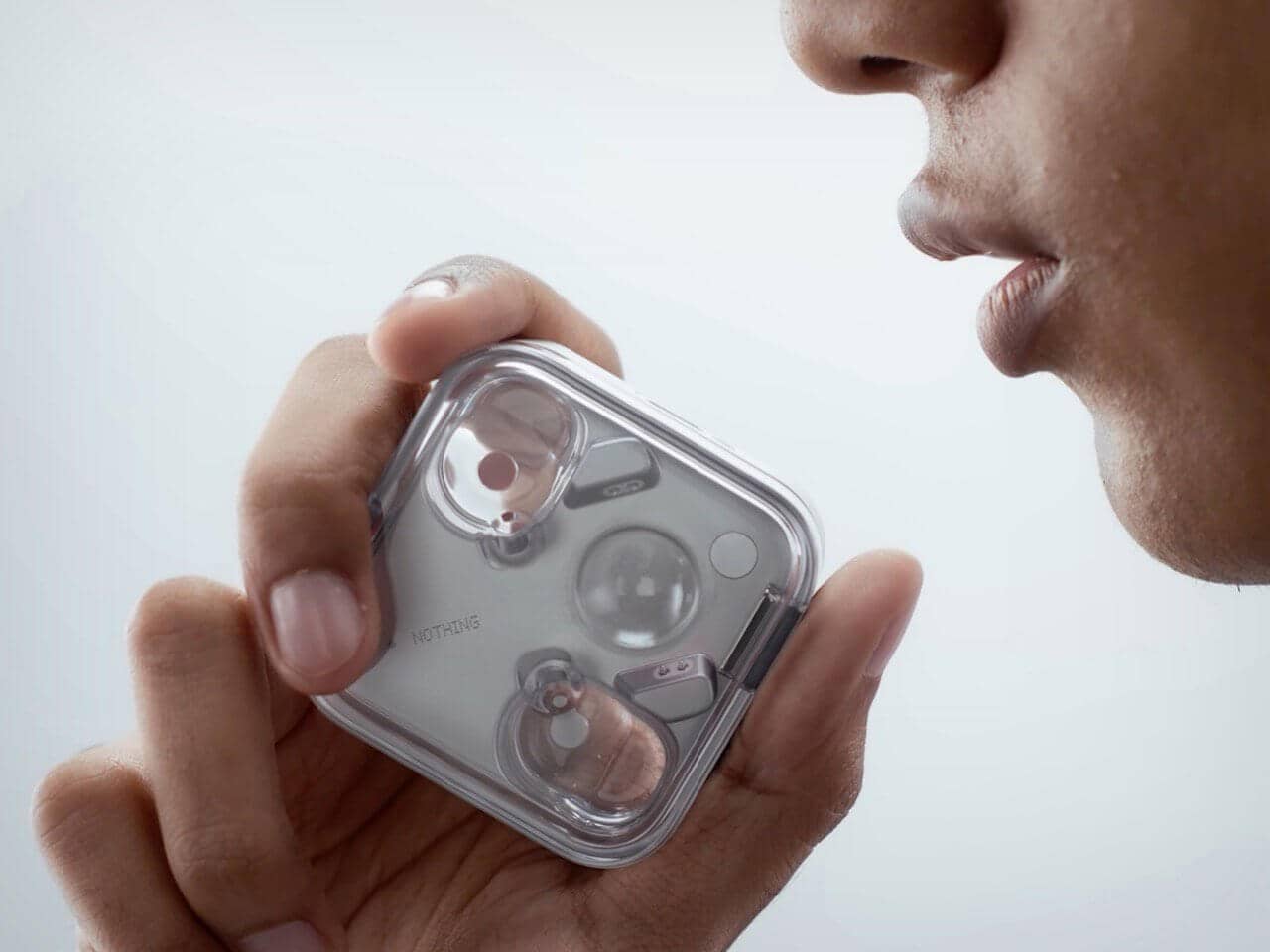 Nothing Ear (3) earbuds laid out on a surface showcasing the transparent design and metal case accents