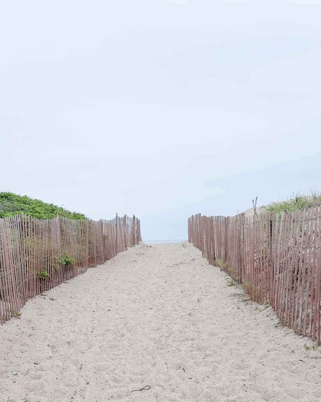image of a beach with sand and fences to show how beautiful it is without ocean plastic