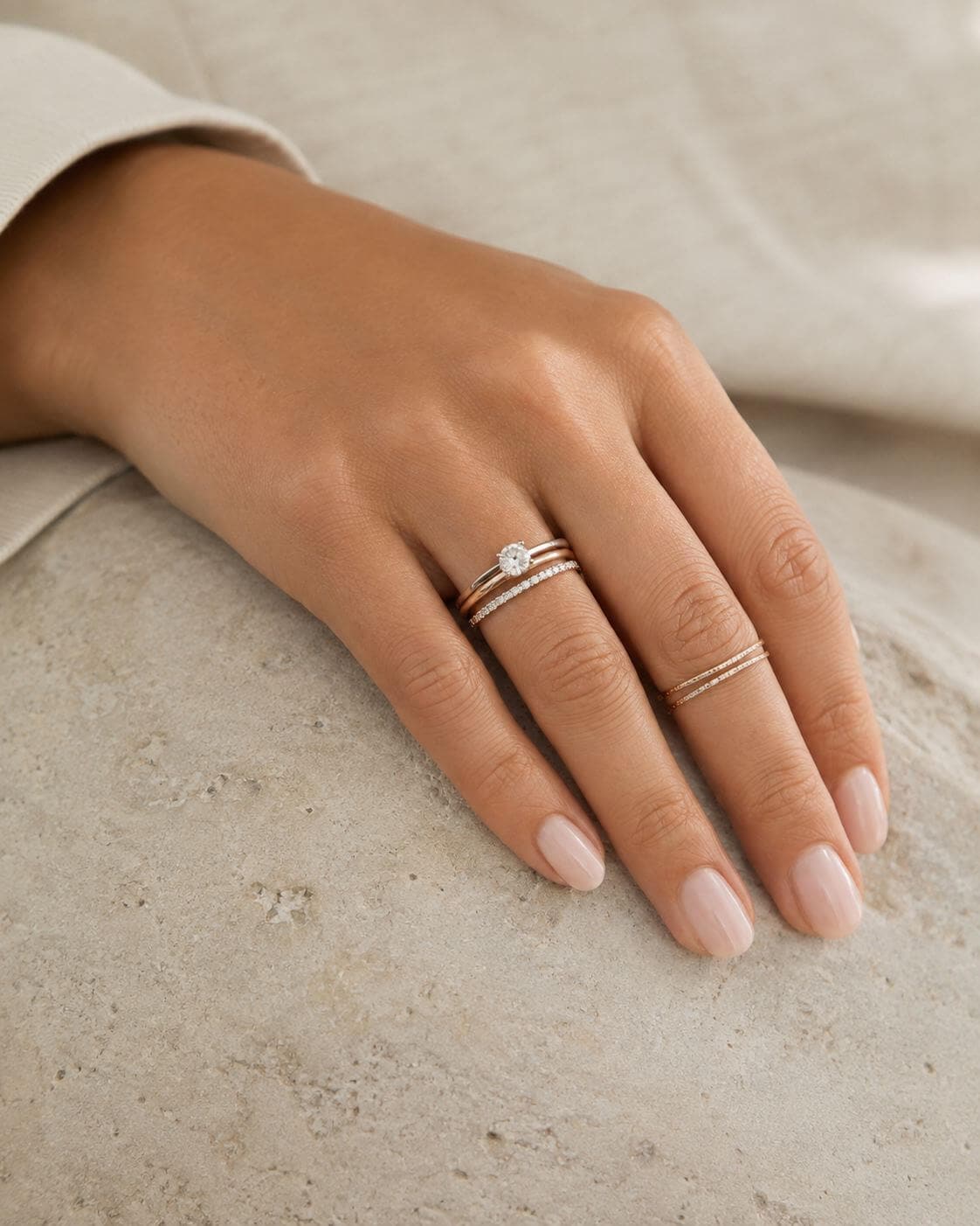 Restrained diamond ring stack with one fine companion ring on another finger