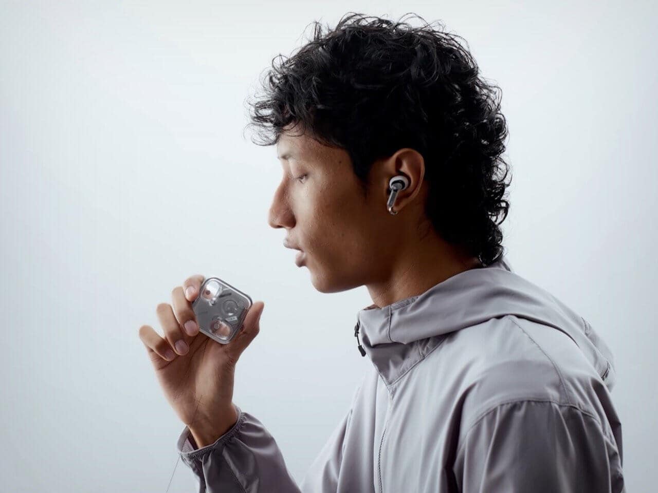 Side view of Nothing Ear (3) earbuds with charging case on a minimalist background