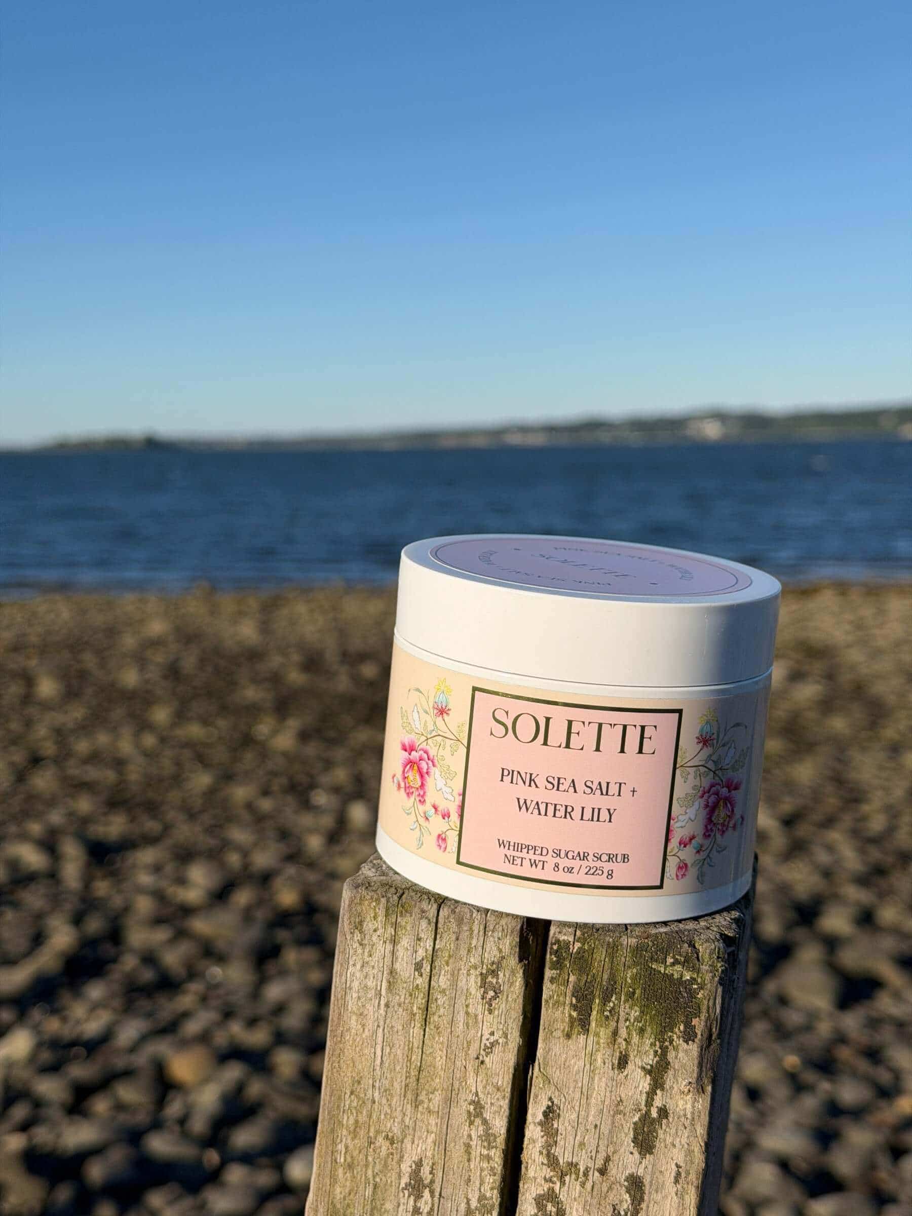 best sensitive skin body care sugar scrub in front of ocean shoreline