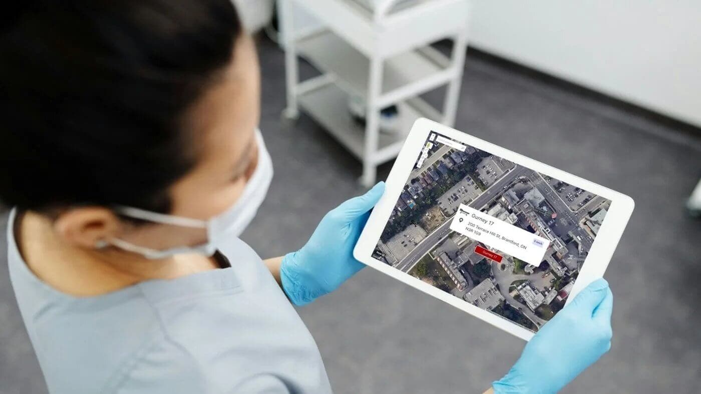 Hospital worker checking location of assets on a tablet
