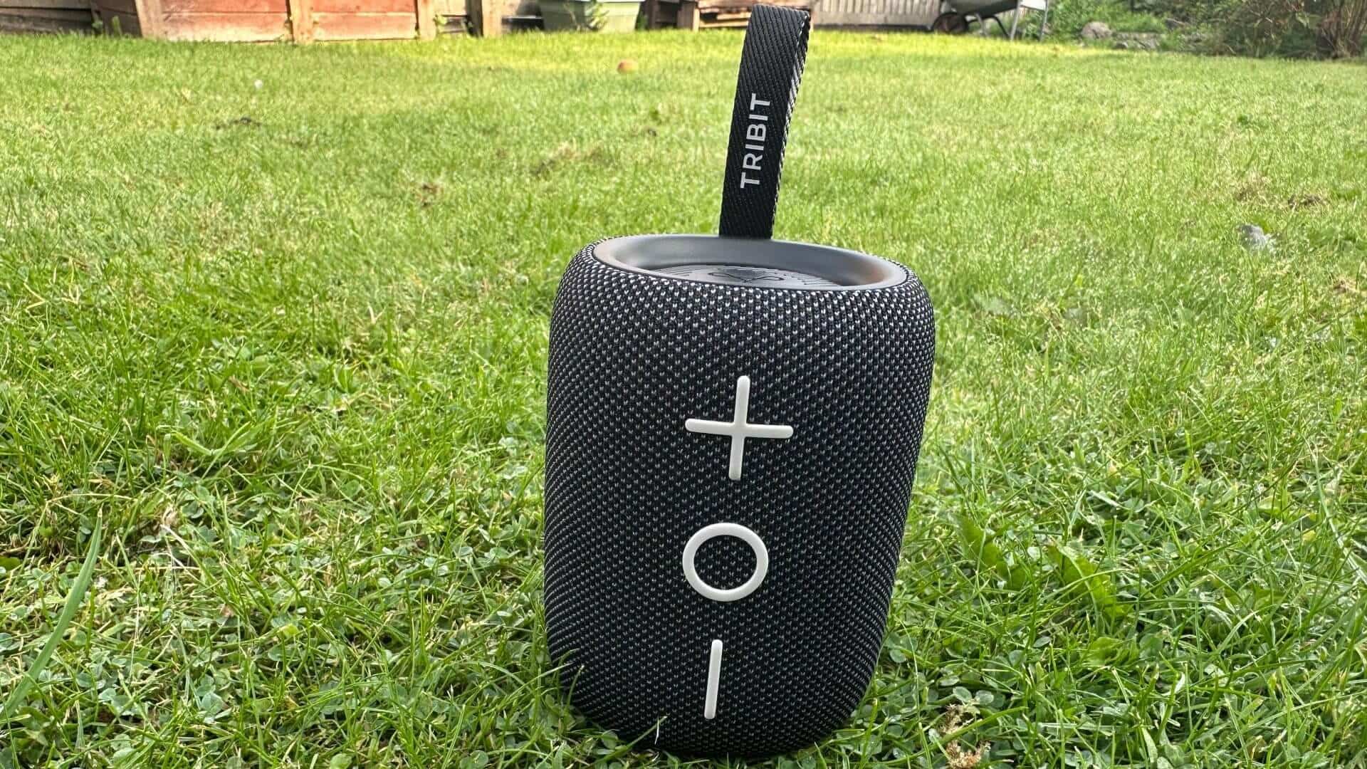 Tribit Stormbox Mini Plus standing out on a grassy patch, ready to play anywhere.
